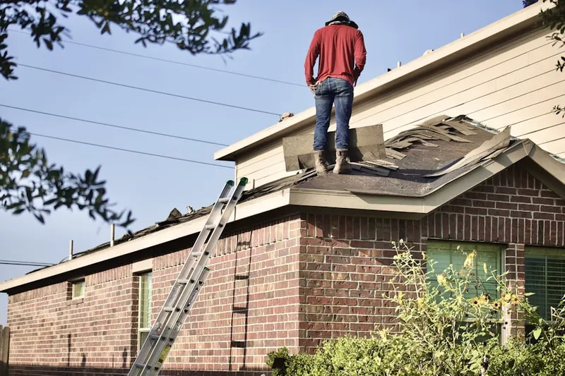 Professional roofer working on a residential roof in Geddes